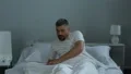 Sick man in bed putting nasal drops in nose and falling asleep disease treatment HD Footage