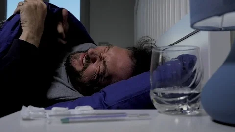Sick man in bed with very strong headache and fever slow motion Stock Footage 76749191