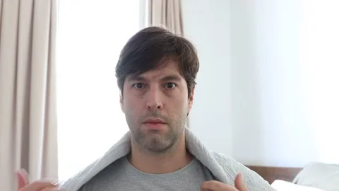 A sick man with a blanket on his back, shaking sick in 4k Stock Footage 132360759