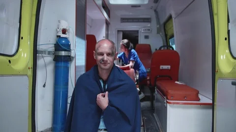 Sick man in blanket sit and smile, in the background nurse. Stock Footage 116986188
