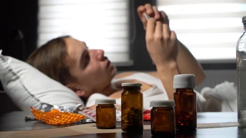 Sick man checking temperature.Sick man lying on bed Stock Footage 125809763