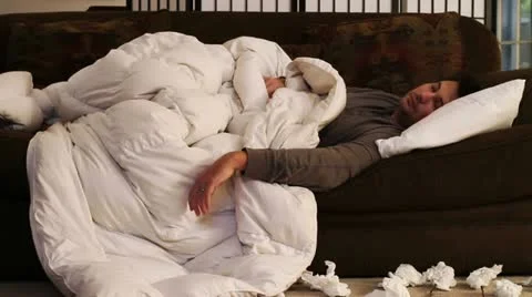 Sick man on couch coughing Stock Footage