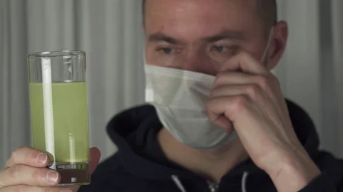 Sick man drinking effervescent antipyretics pill dissolved in glass of water Stock Footage 71903174