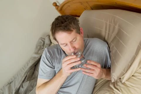Sick man drinking water Stock Photos