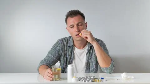 A sick man drinks a cold pill - home treatment Stock Photos