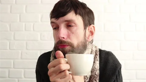 Sick man feel cold drinking hot steaming beverage from white cup close up Stock Footage 150744728