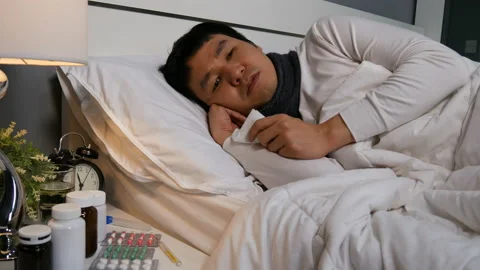 Sick man feeling cold and sneezing in a bed., 4k video Stock Footage 130734556