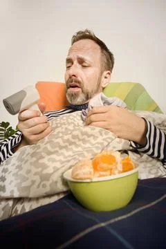 Sick man with flu and cold healing fever and sickness in home bed Foto stock