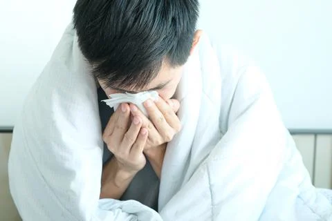 Sick man is flu, using a paper napkin and he have a runny nose. And he was co Stock Photos