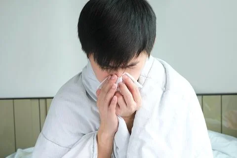 Sick man is flu, using a paper napkin and he have a runny nose. And he was .. Stock Photos