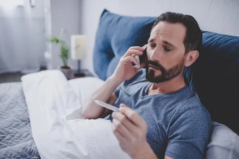 Sick man holding thermometer Stock Photos