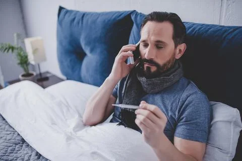 Sick man holding thermometer Stock Photos