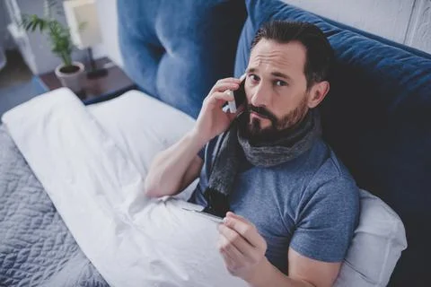 Sick man holding thermometer Stock Photos