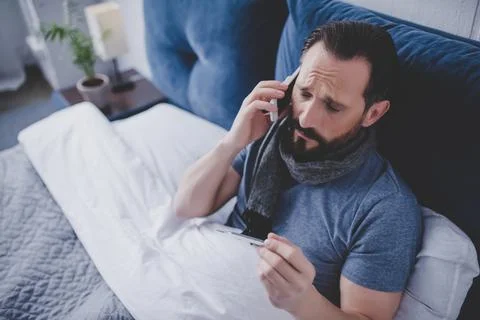 Sick man holding thermometer Stock Photos