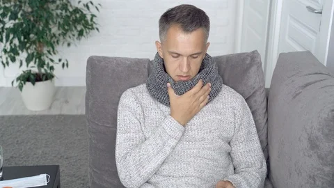 Sick man holding a thermometer sitting on the couch. Healthcare concept Stock Footage 111752376