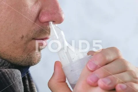 Sick man inhaling through inhaler nozzle for nose. Close-up nose, side view. Use Stock Photos