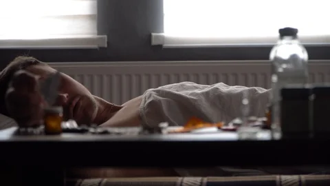 Sick man looking for the right medication on the table Stock Footage 125809936