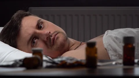 Sick man looking for the right medication on the table Stock Footage 125809939