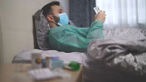 Sick man lying in bed next to his medications in his home Stock Footage 128812263