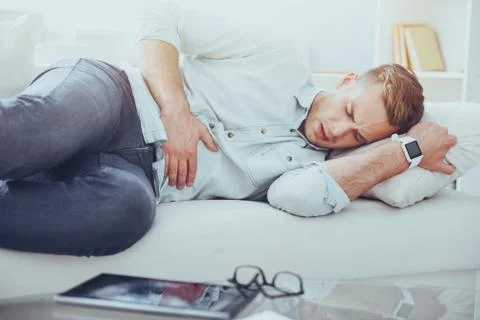 Sick man lying on the couch Foto stock