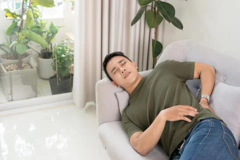 Sick man lying on the couch Stock Photos