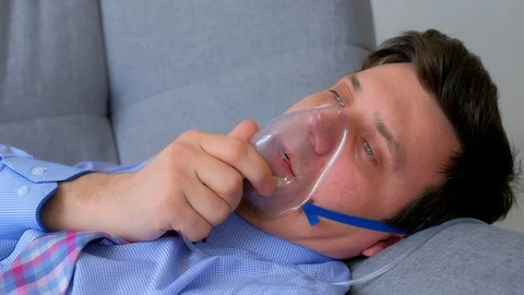 Sick man in oxygen mask due to difficulty in breathing in coronavirus pandemic. Video stock 129140372