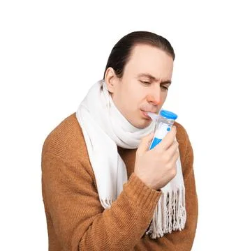 Sick man with a red nose using a portable nebulizer for respiratory treatme.. Stock Photos