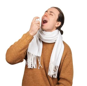 Sick man in scarf using throat spray to treat sore throat isolated on white.. 스톡 사진