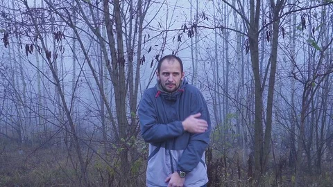 Sick man shivers due to cold autumn or fall weather in the outdoor Stock Footage 115351417
