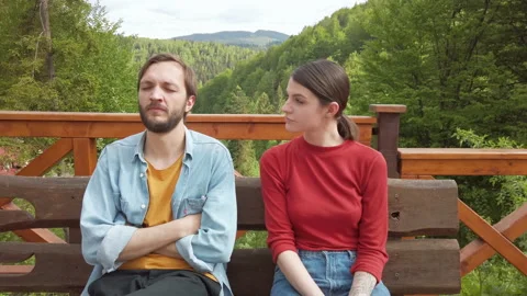 Sick man sits on a bench next to woman and sneezes, woman afraid of illness run  Video stock 130757972