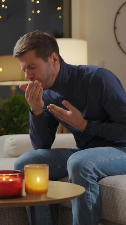 Sick man sitting on sofa holding chest with pain at home Stock Footage 328448877