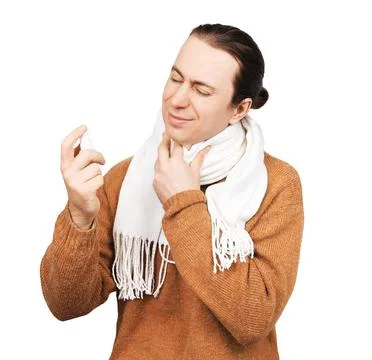 Sick man with a sore throat using a medical spray. Concept of treating flu,.. Stock Photos