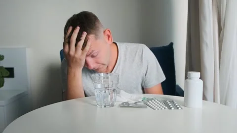 Sick man suffering from headache, migraine holding this head at home with Stock Footage 315861612