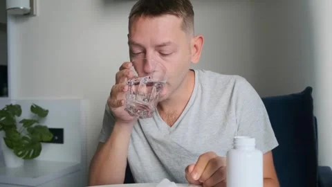 Sick man taking medicine to relieve headache, migraine , reduce fever and treat Stock Footage 315860920