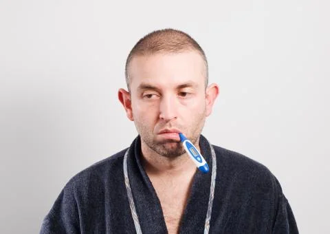 Sick man with a thermometer looking down Stock Photos