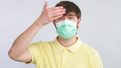 Sick man touching his forehead to check body temperature wearing protection Stock Footage 127109708