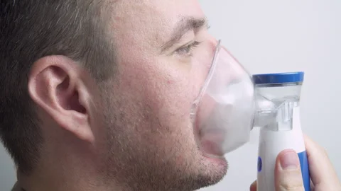 Sick man is using nebulizer at home Stock Footage 314776174