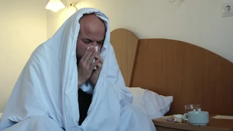 Sick mature man sitting on bed in bedroom or in hotel room and blowing nose Stock-Footage 302156554