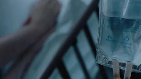 A sick middle aged man with an IV drip recovering in a hospital bed, slow Stock Footage 74394970