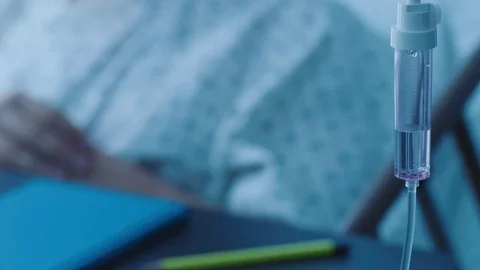 A sick middle aged man with an IV drip resting in a hospital bed, slow motion, Stock Footage 74399676