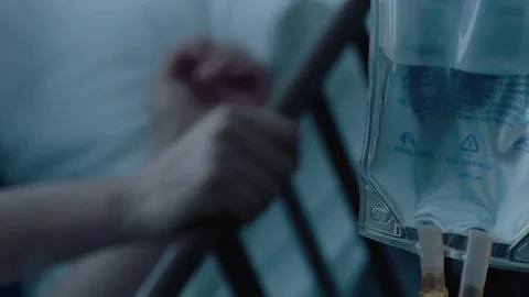A sick middle aged man with an IV drip recovering in a hospital bed, slow Stock Footage 74399896