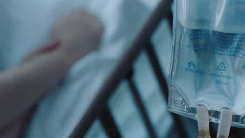 A sick middle aged man with an IV drip recovering in a hospital bed, slow Stock Footage 74400826