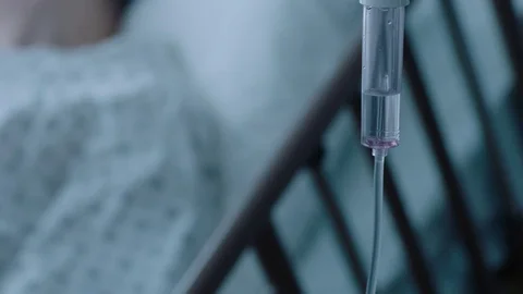 A sick middle aged man with an IV drip recovering in a hospital bed, slow Stock Footage 74401237