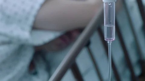 A sick middle aged man with an IV drip recovering in a hospital bed, slow Stock Footage 74401944
