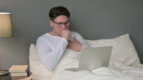 Sick Middle Aged Man with Laptop Coughing in Bed 스톡 동영상 142367654