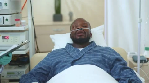 Sick miserable exhausted afro-american guy lying in private clinic hospital Stock Footage 142594211