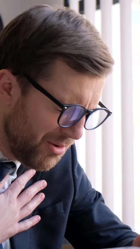Sick office worker at the workplace. Shortness of breath in a young man. Busy Stock Footage 246848849