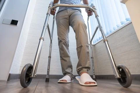 Sick person moves with the help of special walkers. Problems with the musculo Stock Photos