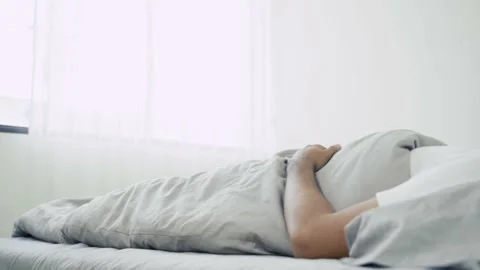 A sick person wake up because he feeling back pain, he try to relax hisself and  Stock Footage 135295302