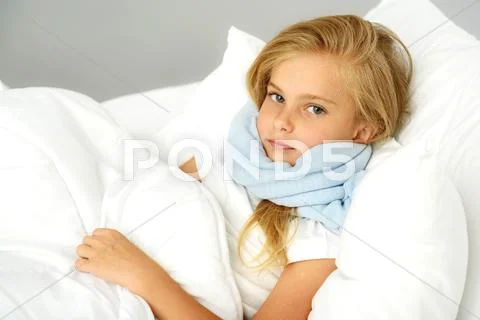 Sick preschool girl lying in the bed Stock Photos
